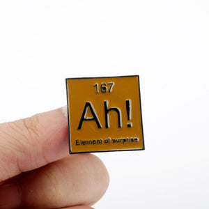 AH ELEMENT OF SURPRISE ENAMEL BADGE PERIODIC BROWN